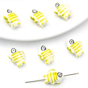 Macro detail of fish-shaped ceramic beads with yellow-green stripes for DIY jewelry making