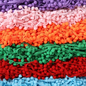 Close-up of vibrant 10mm pom pom fringe trim in assorted colors for DIY sewing crafts