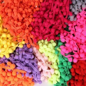 Detailed close-up of multi-colored 10mm pom-pom trim ribbons for DIY sewing crafts
