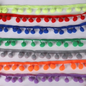 Close-up of colorful 10mm pom-pom fringe trim in assorted colors for DIY sewing crafts