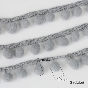 Macro detail of grey 20mm pom pom trim ribbon with 10mm soft knit balls on white background