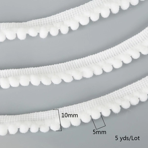 Detail of 10mm white pom-pom lace trim showing 5mm ball diameter and soft fabric texture