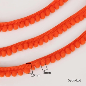 Detail of 10mm bright orange pom-pom fringe trim with 5mm fluffy balls for DIY sewing