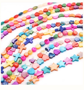 Macro shot of colorful shell beads in heart and star shapes with pearlescent luster