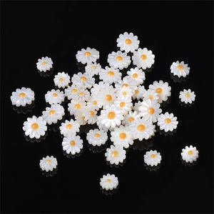 Natürliche Muschel-Gänseblümchen-Anhänger für DIY-Schmuck auf reflektierendem Hintergrund
