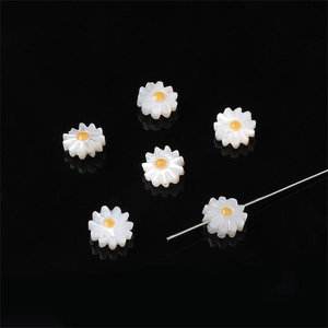 Makro-Detail von Gänseblümchen-Perlen für DIY-Schmuck mit weißen Blüten und gelber Mitte