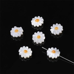 Detail von sechs Gänseblümchen-Anhängern aus Muschelperlen für DIY-Schmuckherstellung