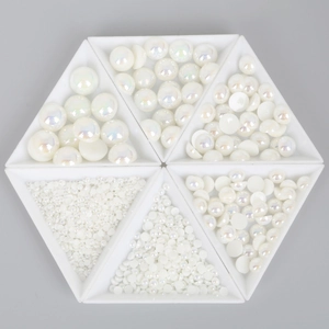 Detail van witte iriserende ABS-halve parels in zeshoekige bakjes voor DIY-knutselwerk