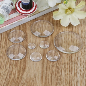 Close-up of clear round glass cabochons in various sizes for DIY jewelry making