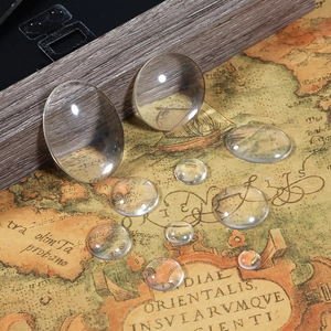 Macro view of transparent round and oval glass cabochons on a vintage map background