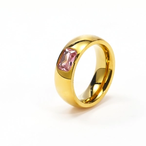 Detalle macro del anillo dorado con circonita rosa cuadrada y acabado pulido espejo