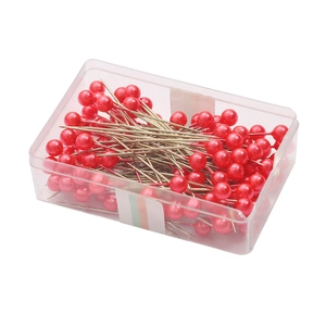 Metallic red pearl head sewing pins in a clear plastic storage box for DIY craft projects