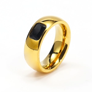 Detalle de un anillo ancho de acero dorado con una piedra preciosa negra rectangular