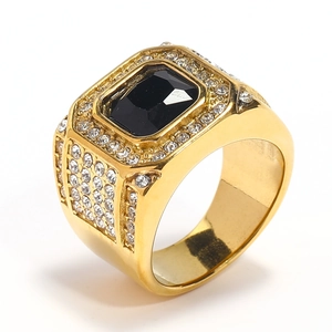 Detail van heren gouden hiphop ring met grote zwarte steen en kristallen micro-paving