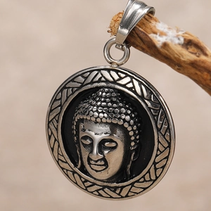 Macro shot of Buddha head relief pendant in vintage stainless steel with textured edge