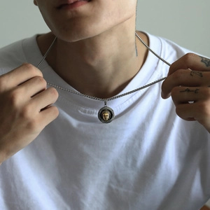 Close-up of vintage punk round Buddha pendant necklace with silver box chain on model