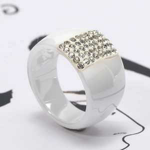 Elegant white ceramic ring with multiple rows of sparkling crystals in a minimalist design