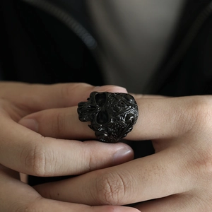 Nahaufnahme des gotischen Totenkopfrings in Gunmetal-Optik mit geprägten Mustern am Finger