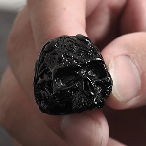 Nahaufnahme eines Punk-Totenkopfrings mit eingraviertem Freimaurer-Symbol und G-Zeichen