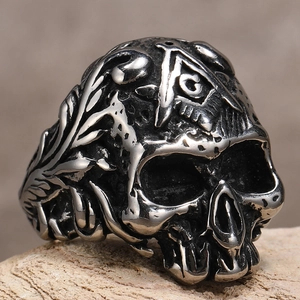 Detailaufnahme von Punk-Totenkopfring mit Freimaurer-Symbol und Blumenmustern