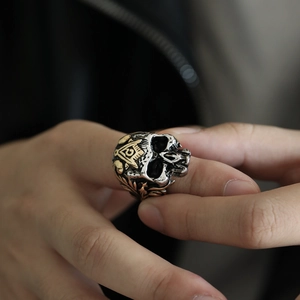 Makroaufnahme von Vintage-Totenkopfring mit goldenem Freimaurer-Symbol und Punk-Finish