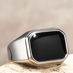 Dettaglio macro dell'anello geometrico da uomo in acciaio titanio con smalto nero lucido