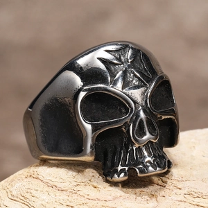 Dettaglio macro di anello teschio gotico con incisione a croce su metallo vintage