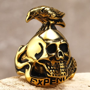 Macro shot of gold punk eagle skull ring with engraved EXPEND text on the band