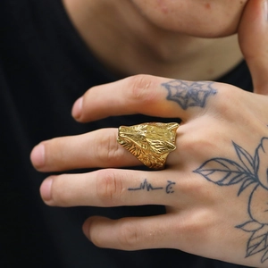 Detailed close-up of a golden wolf head ring featuring realistic punk rock style engraving