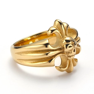 Macro shot of gold gothic skull ring featuring fleur-de-lis engravings and polished finish