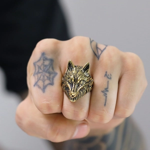 Detailed close-up of a vintage wolf head ring with intricate fur texture on male hand