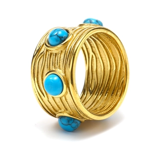 Vue détaillée d'une bague en acier titane doré avec pierres turquoises et texture écorce