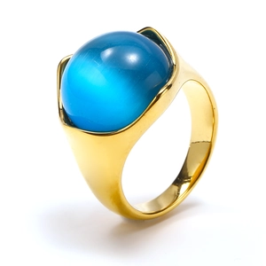 Detail view of a thick gold titanium ring featuring a large cabochon blue cat eye stone
