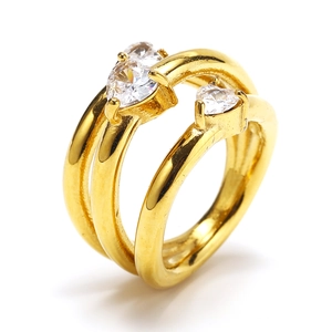 Dettaglio macro dell'anello dorato a doppio strato con tre zirconi a forma di cuore