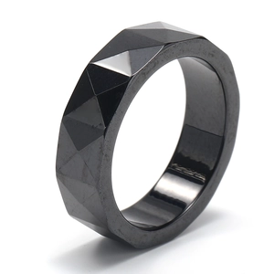 Macro detail of a faceted black bioceramic ring featuring modern geometric cutting design