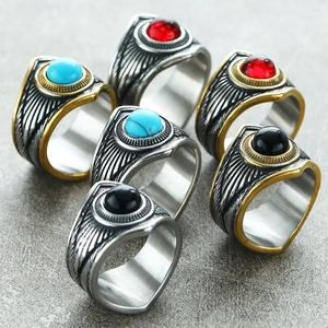 Detalle de anillos punk retro con piedras preciosas y grabados de plumas laterales