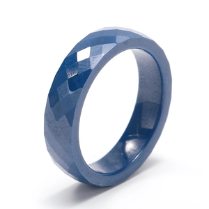Macro detail of navy blue faceted bioceramic ring with geometric light reflections