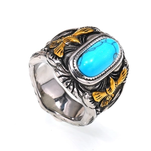 Makroaufnahme eines Retro-Titanrings mit blauem Türkis und goldenen Adler-Details