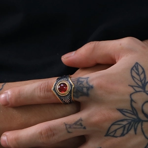 Primer plano de anillo punk vintage con piedra roja y detalles grabados en oro