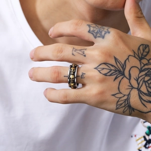Vista dettagliata dell'anello teschio punk in metallo oro e nero sulla mano