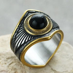 Detalle macro del anillo punk retro con piedra negra y grabado de patrón de pluma