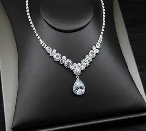 Macro shot of V-shaped bridal necklace with pear-cut rhinestone pendant on a jewelry display