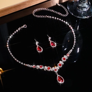 Macro detail of bridal jewelry set with red teardrop stones and sparkling crystals