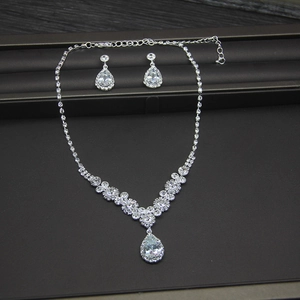 Elegant bridal jewelry set with V-shaped necklace and pear-cut crystal earrings in silver tone