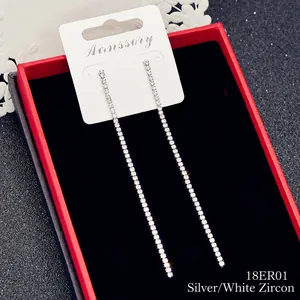 Dettaglio di orecchini pendenti a nappa in argento con strass scintillanti in confezione