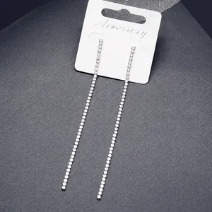 Dettaglio di orecchini pendenti a catena con strass su un cartoncino di presentazione