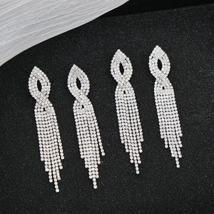 Eleganti orecchini lunghi a nappa color argento con strass scintillanti su fondo nero