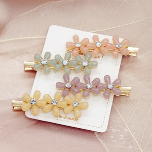 Lot de quatre barrettes à fleurs marguerites en couleurs pastel avec métal doré et strass