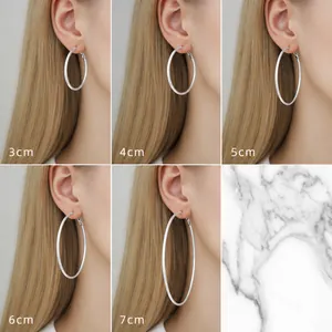 Size comparison of silver hoop earrings ranging from 3cm to 7cm on a female model