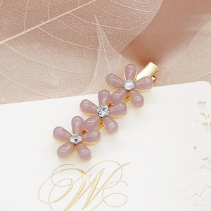 Détail d'une barrette fleur lavande avec base en métal doré et strass étincelants